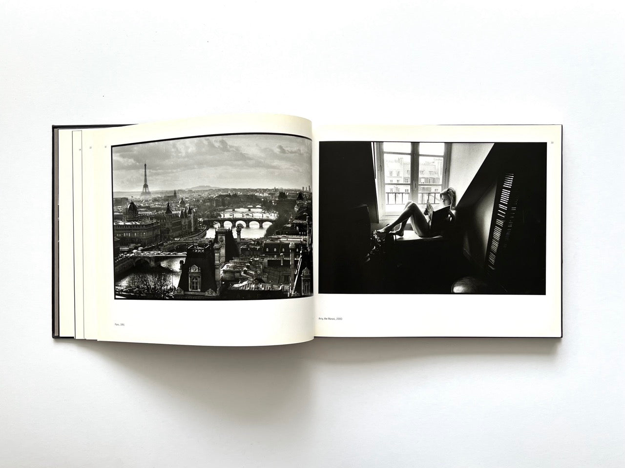 Interior spread from Parisians by Peter Turnley, published in 2000, featuring a panoramic black-and-white view of Paris with the Eiffel Tower alongside a woman reading by a window.