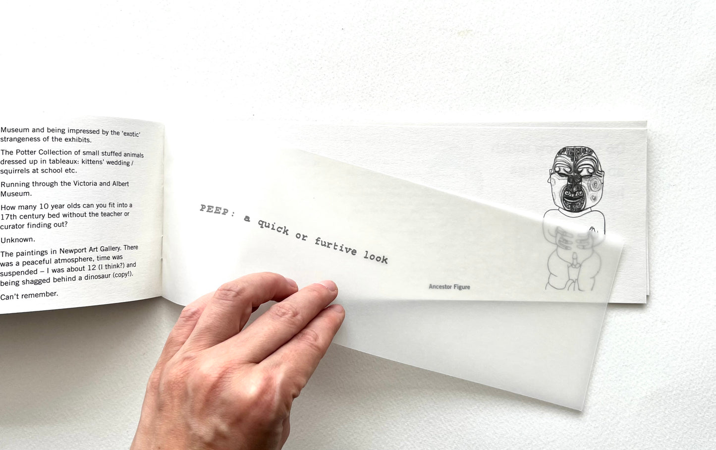 Hand holding an open book with text and illustrations on a white background
