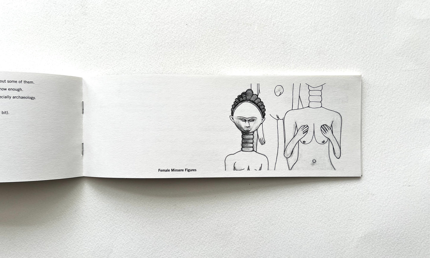 Open book with black entograqphic  line drawings of a woman and a man on a white background