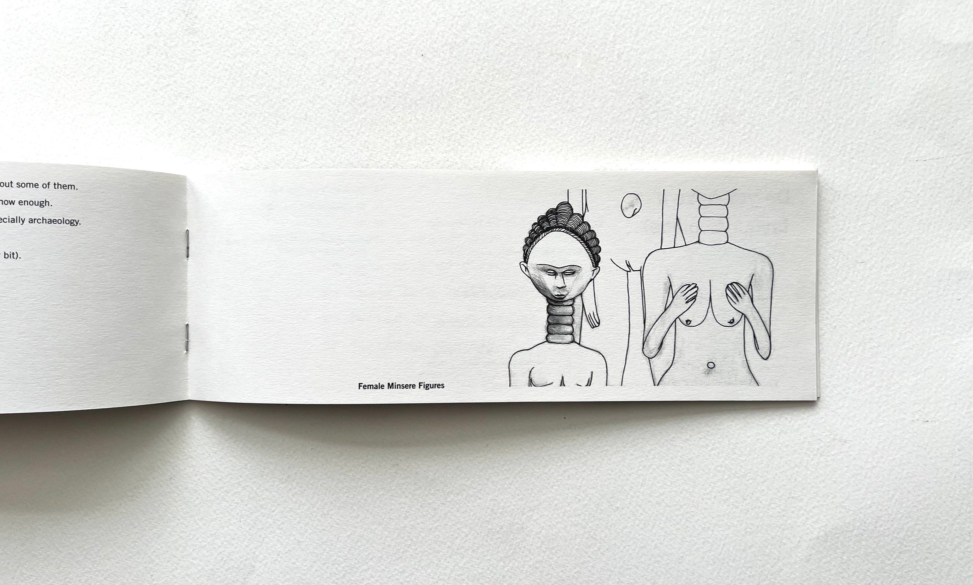 Open book with black entograqphic  line drawings of a woman and a man on a white background