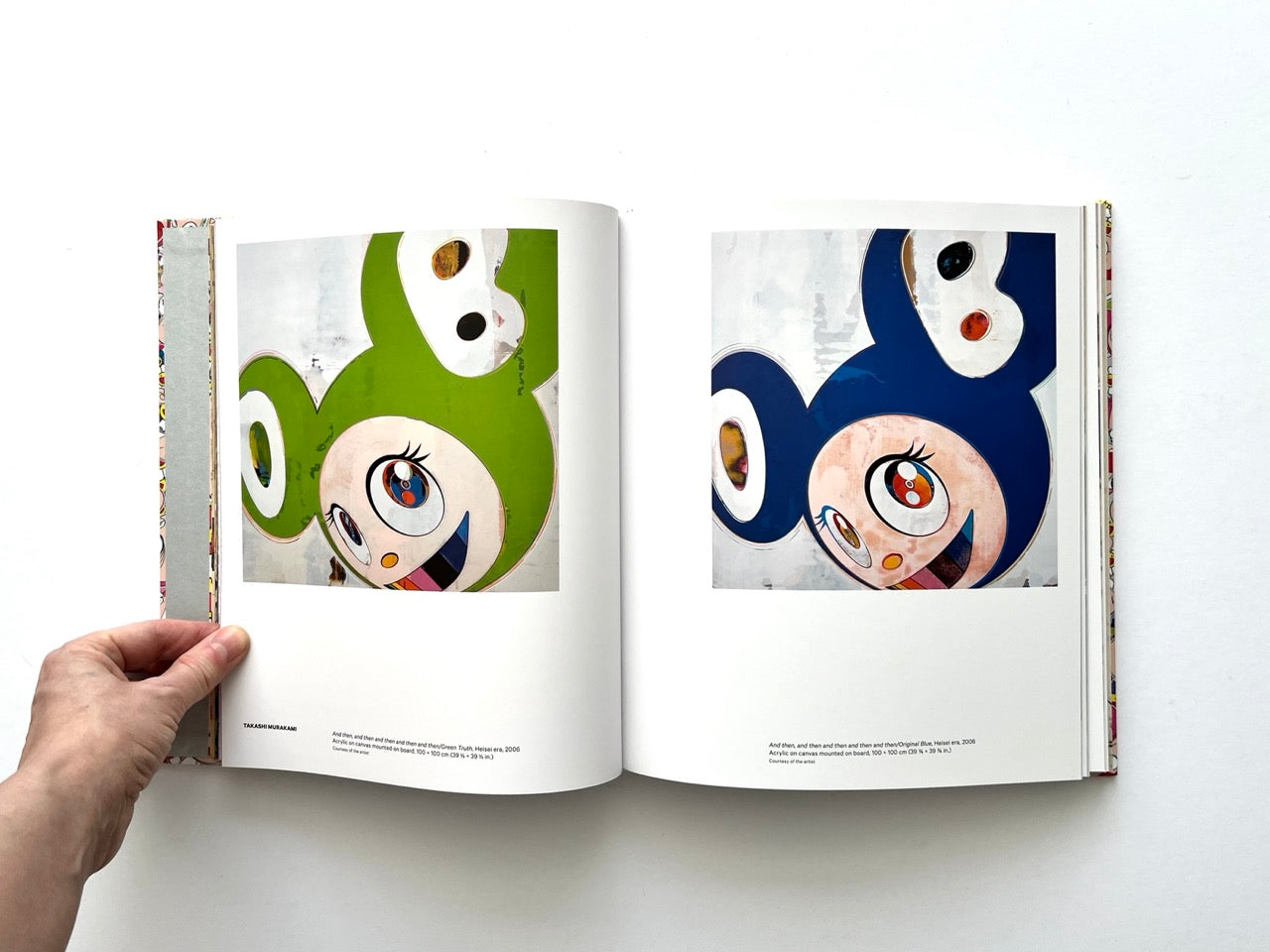 Takashi Murakami Lineage of Eccentrics interior spread showing two square paintings of a stylised cartoon character in green and blue variations