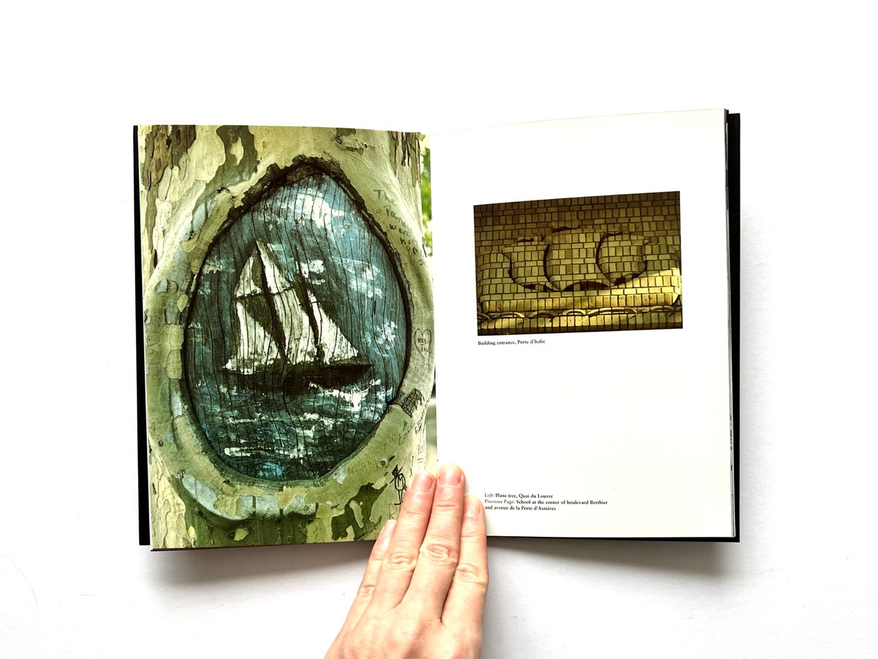 Open spread of Pentagram Papers 24 “The Arms of Paris”, showing a full-page photograph of a painted ship motif carved into a tree trunk on the left and a smaller photograph of a brick architectural detail with circular reliefs on the right, held open by a hand against a white background.