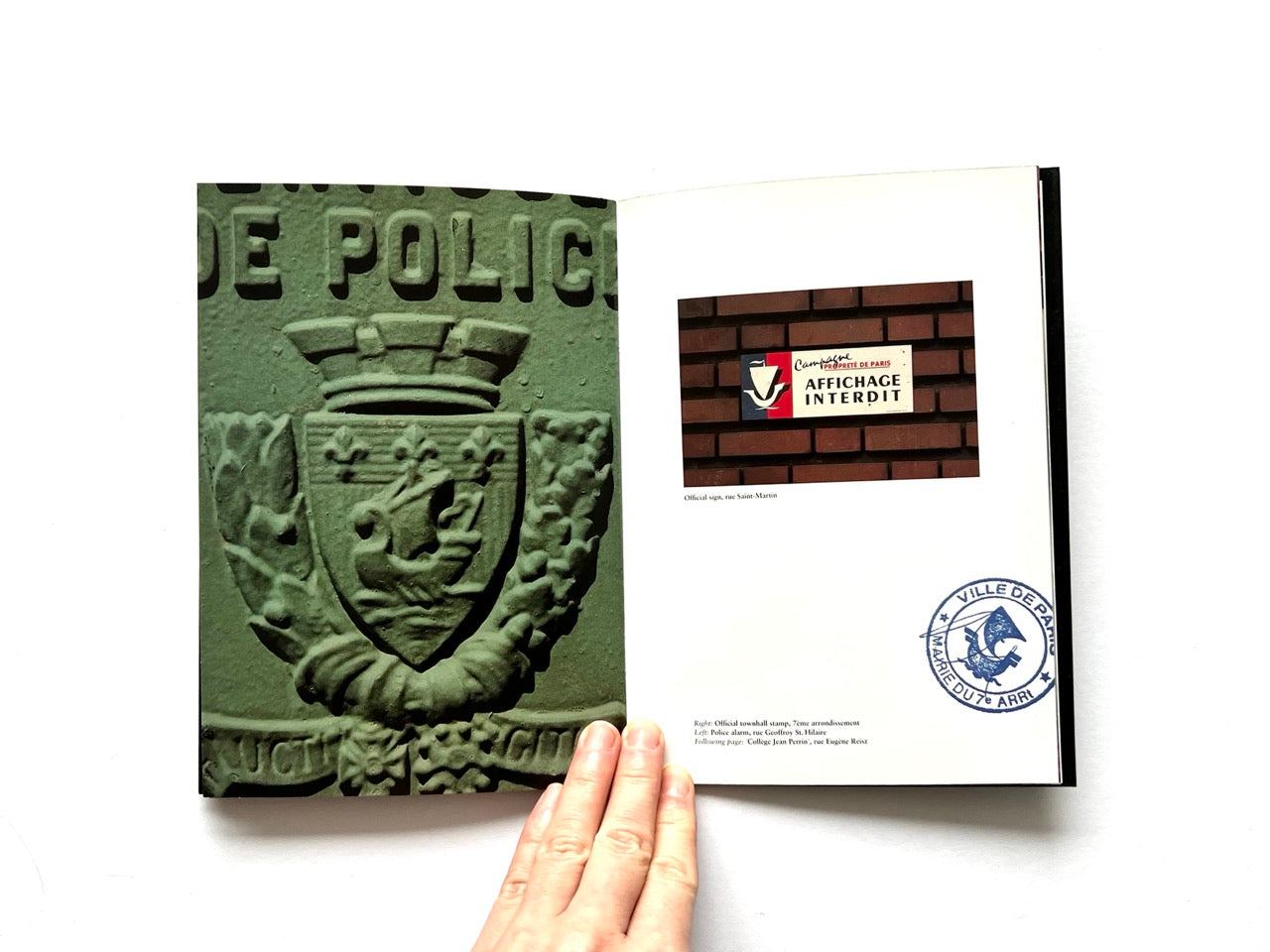 Open spread of Pentagram Papers 24 “The Arms of Paris”, showing a full-page photograph of a green stone municipal crest on the left and two smaller images on the right including a French street sign and an official circular stamp, held open by a hand against a white background.
