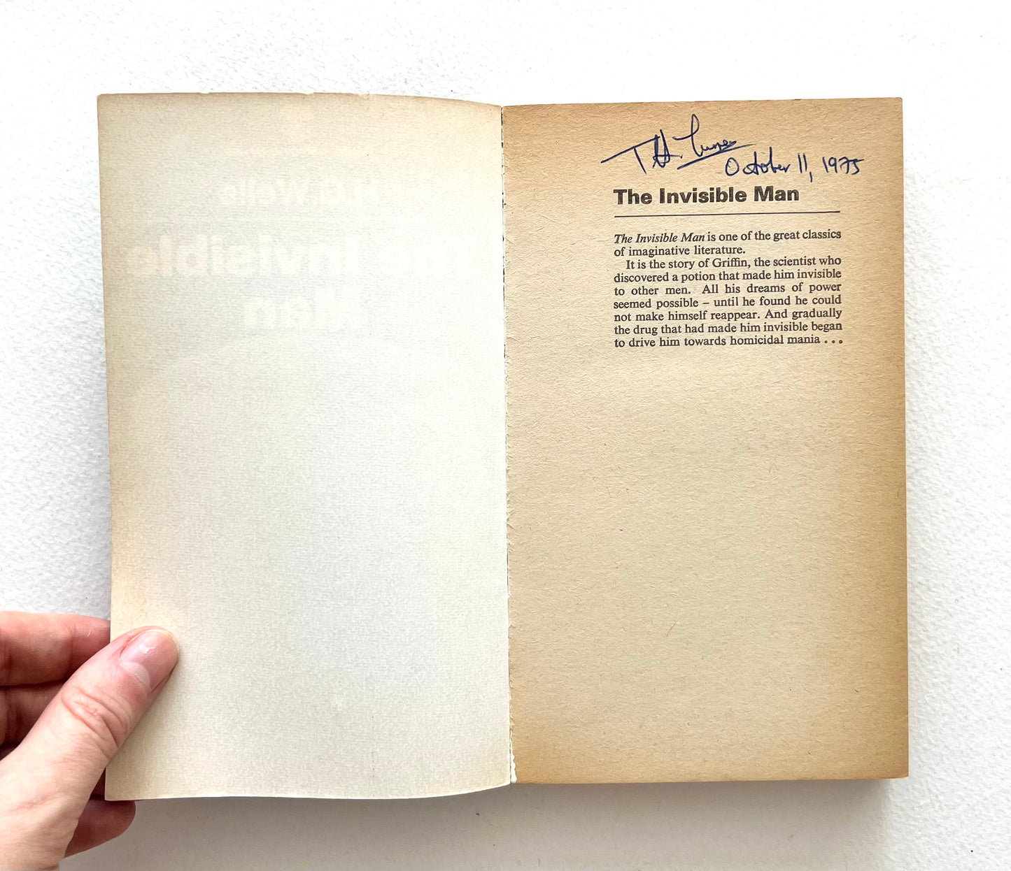 Open book with text and a signature on a white background