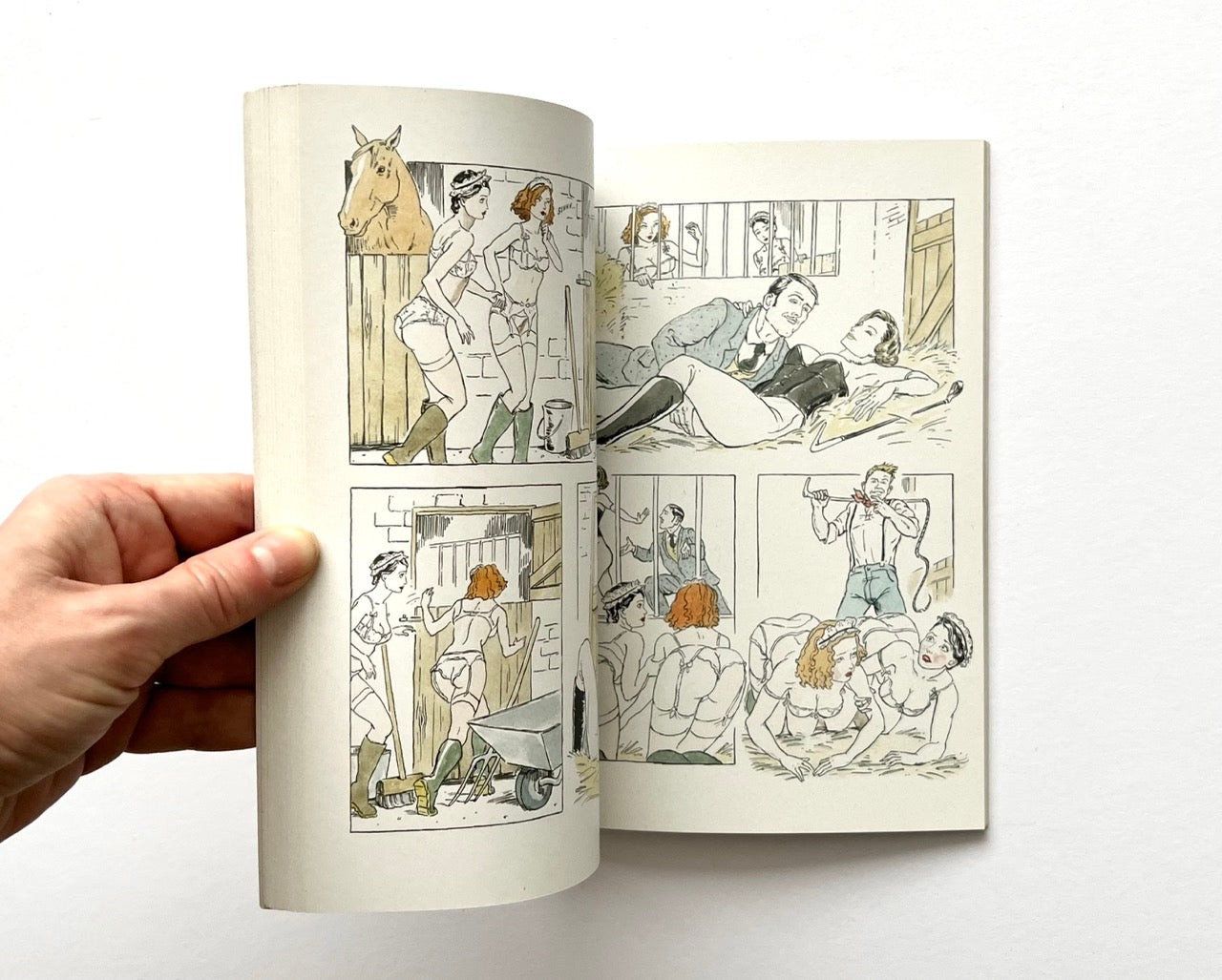 Open book - 'The Lady of the Manor' by Agent Provocateur - with erotic illustrations of women in lingerie in various country house settings.
