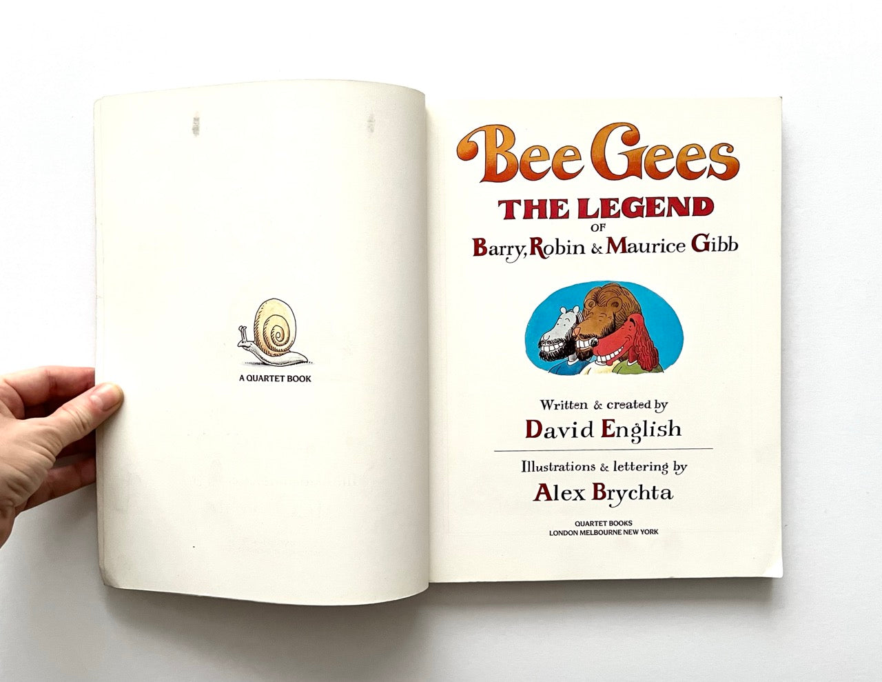 Open book with 'Bee Gees: The Legend' title on a white background