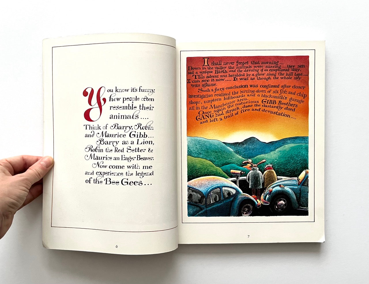 Open book - 'The Legend: The Illustrated Story of the Bee Gees' - with text and illustration of people near cars on a mountain landscape