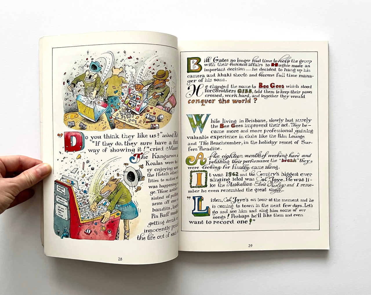 Open book - 'The Legend: The Illustrated Story of the Bee Gees' - with colorful illustrations and text on a white background