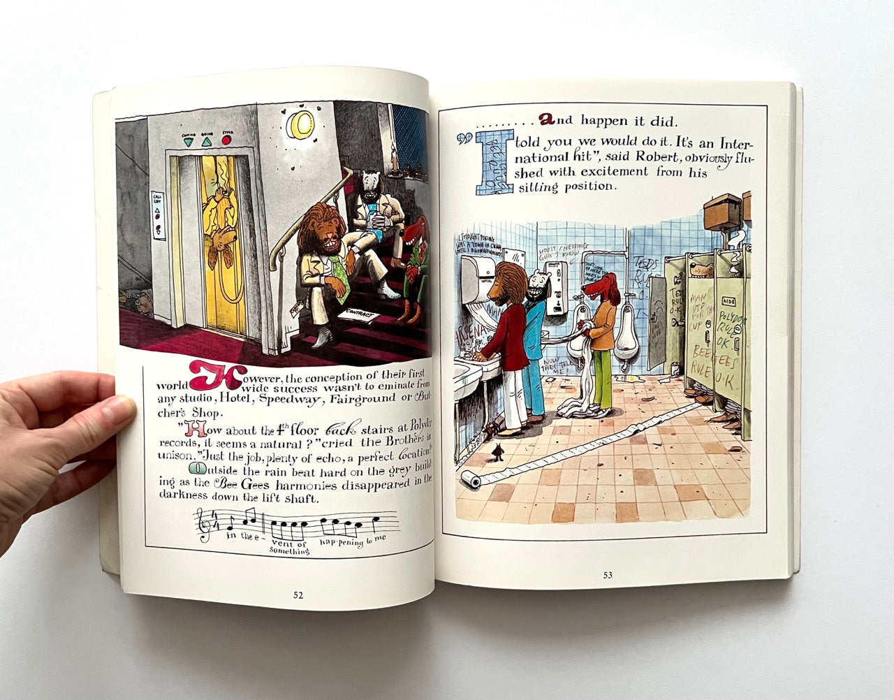 Open book - 'The Legend: The Illustrated Story of the Bee Gees' - showing illustrated pages with characters in a bathroom setting