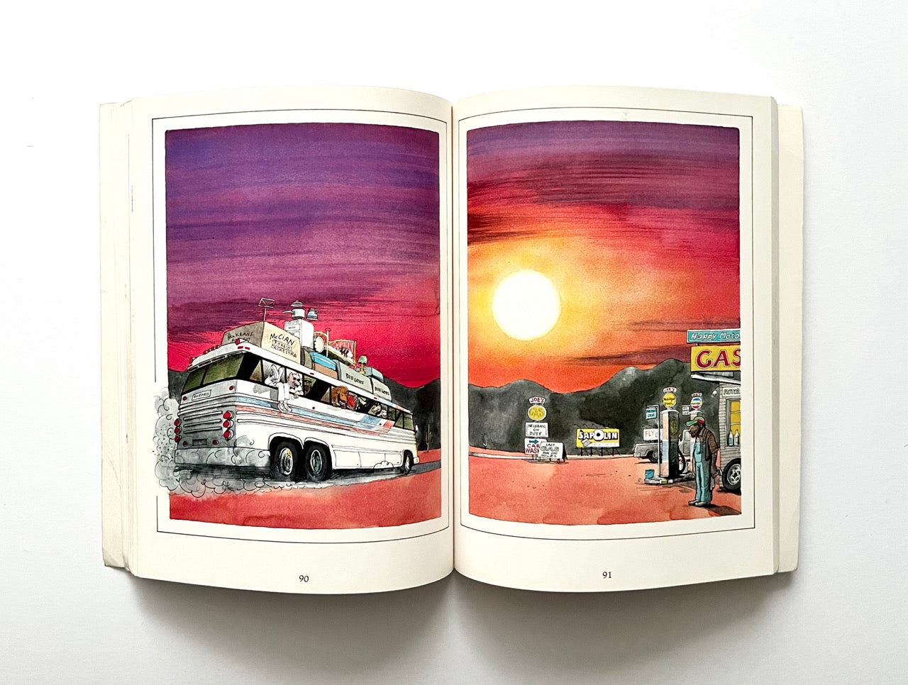 Open book - 'The Legend: The Illustrated Story of the Bee Gees' - showing two illustrations of a bus and a gas station at sunset.