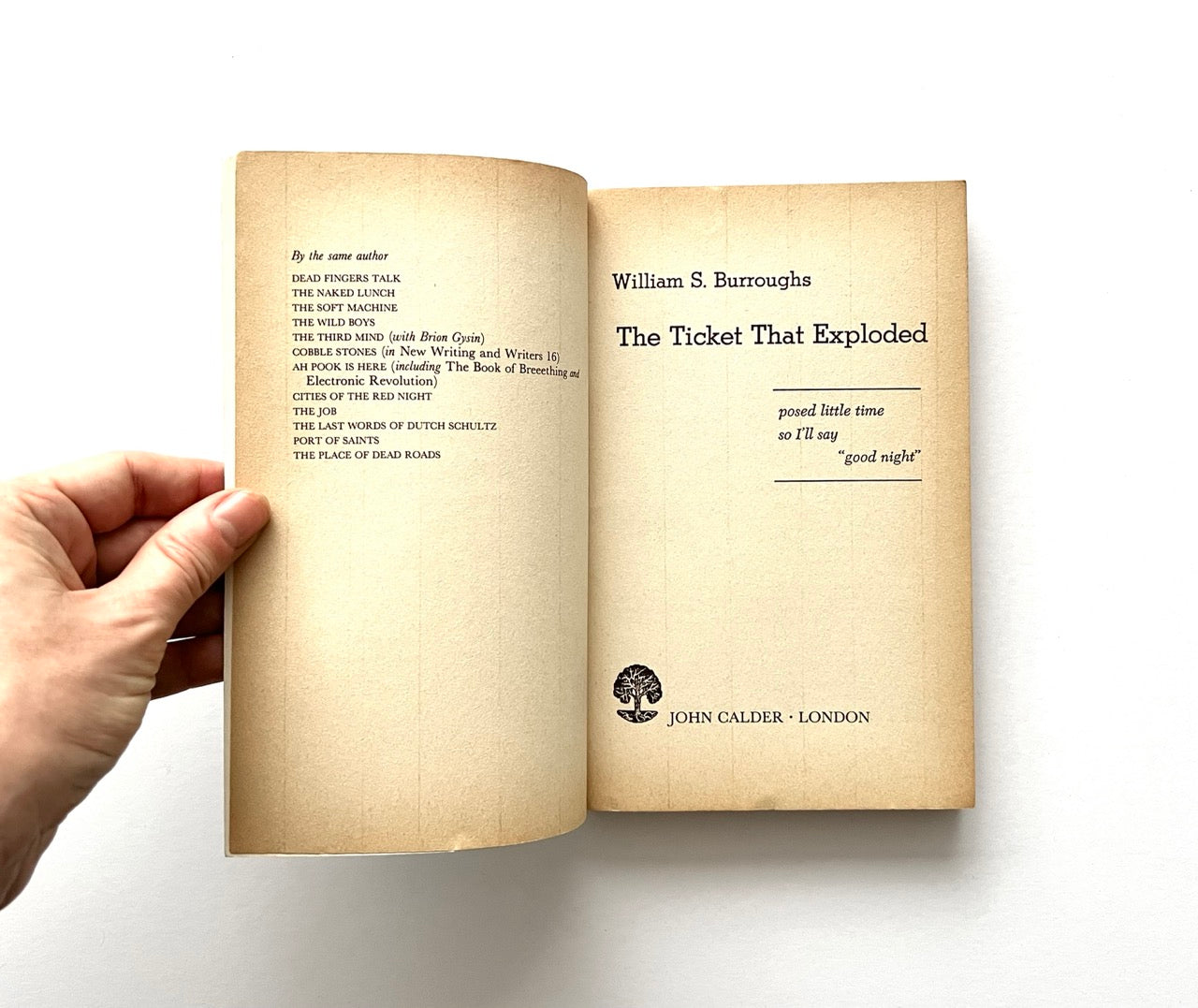 Open book - 'The Ticket That Exploded' by William S. Burroughs - held by a hand.