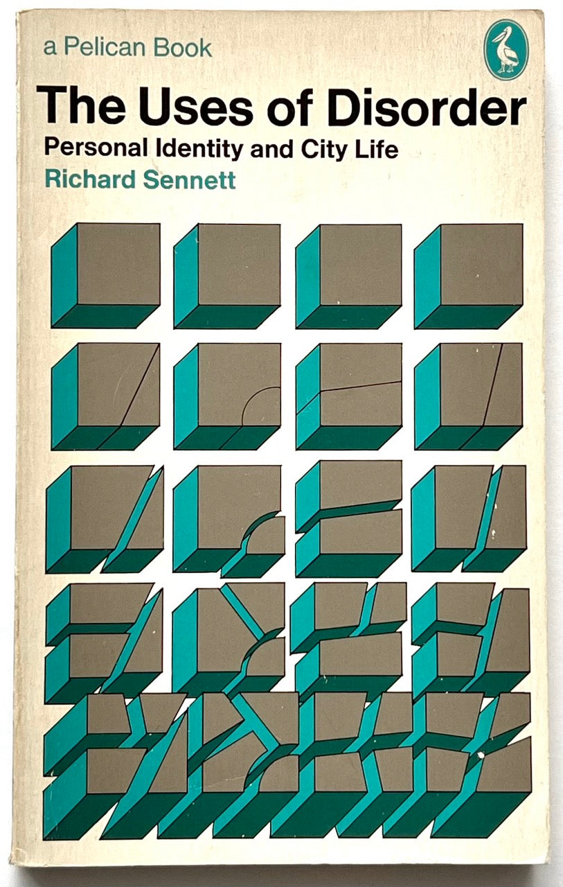 Vintage Pelican paperback cover of The Uses of Disorder: Personal Identity and City Life by Richard Sennett, featuring a cream background, bold black and teal typography, and a geometric illustration of teal and grey cubes progressively fractured and displaced.