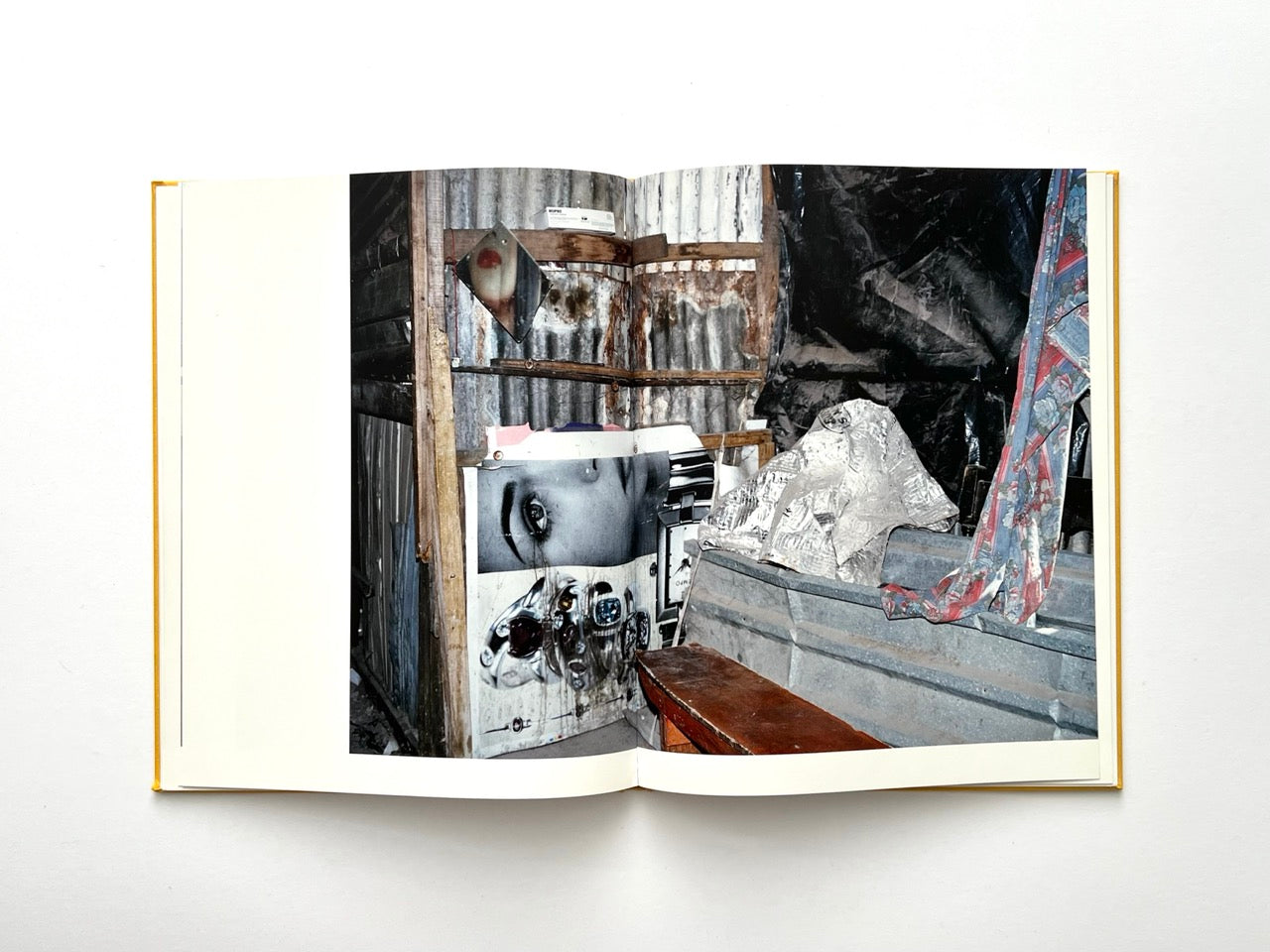 Die Son Sien Alles by Viviane Sassen (2012), interior spread depicting a rough interior with corrugated metal, layered posters and found objects, textured and atmospheric.