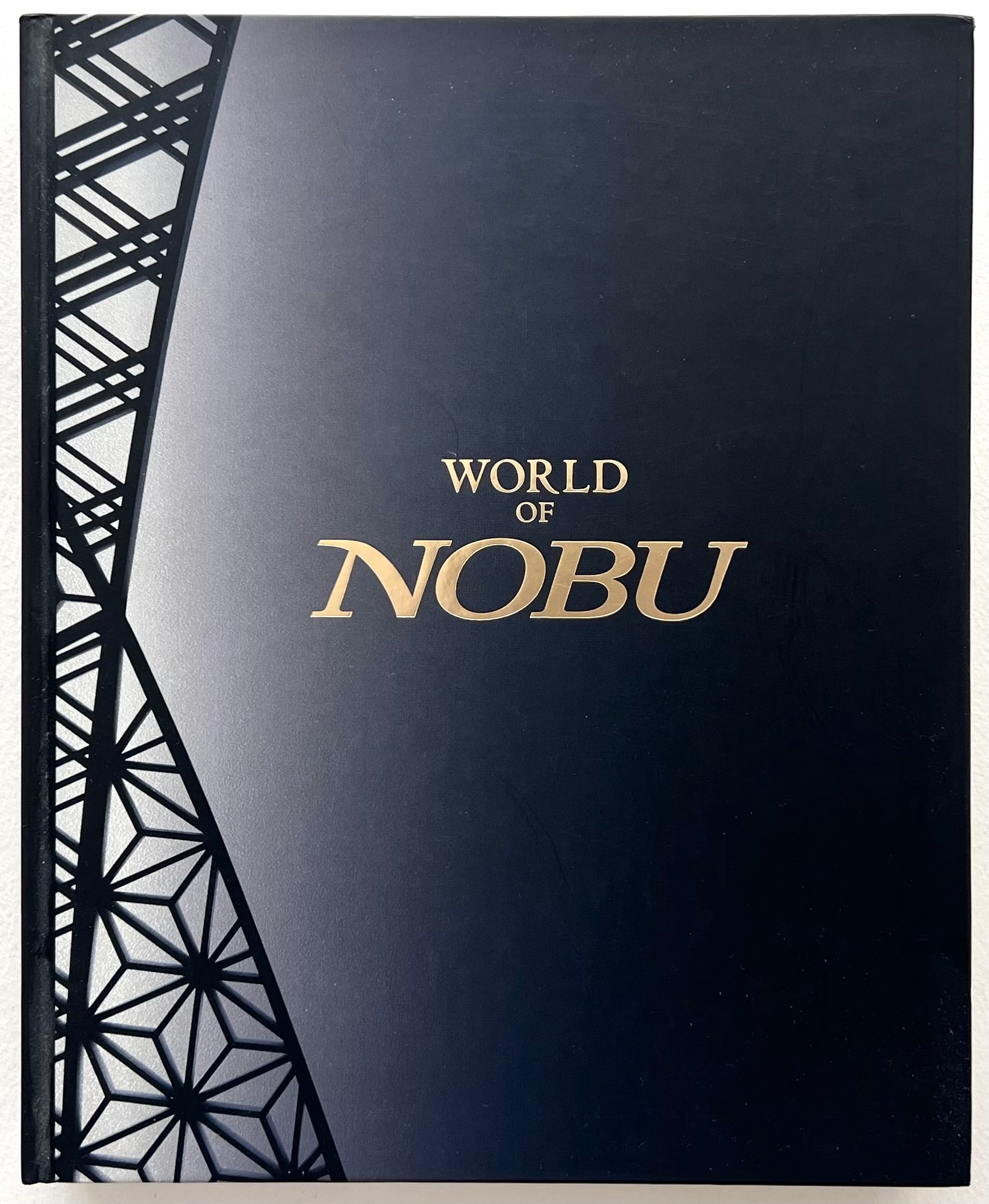 Dark blue book cover with 'World of Nobu' text and geometric patterns