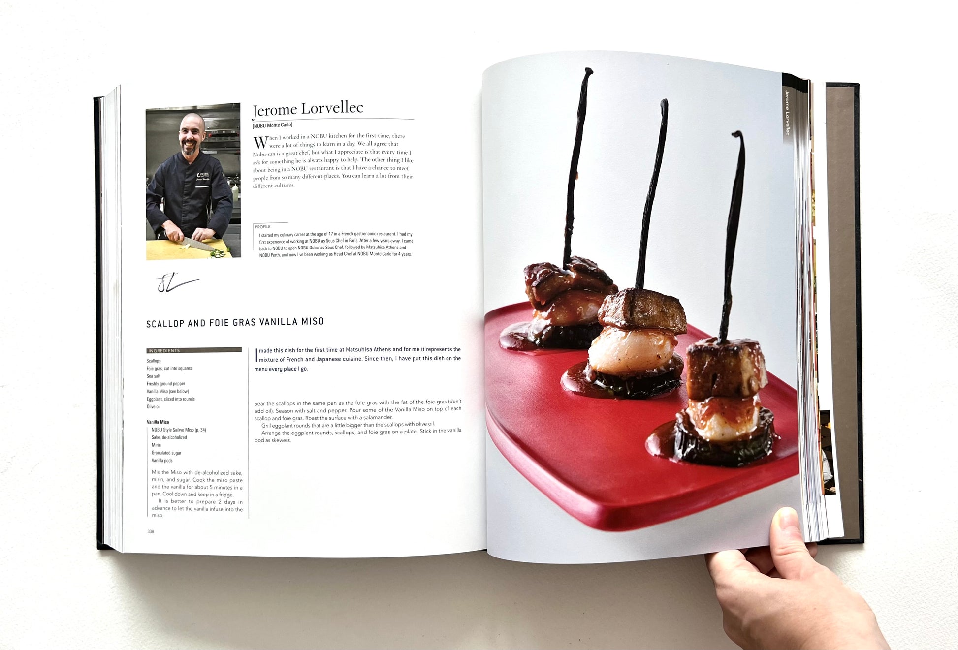 Open "World of Nobu" cookbook showing a recipe and a photo of a SCALLOP AND FOIE GRAS VANILLA MISO dish - signed by chef Jerome Lorvellec.