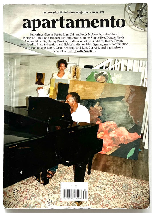 Apartamento Magazine Issue #21 - front cover featuring a domestic interior scene with a grand piano, stacked paintings, and artists in a lived-in studio setting.
