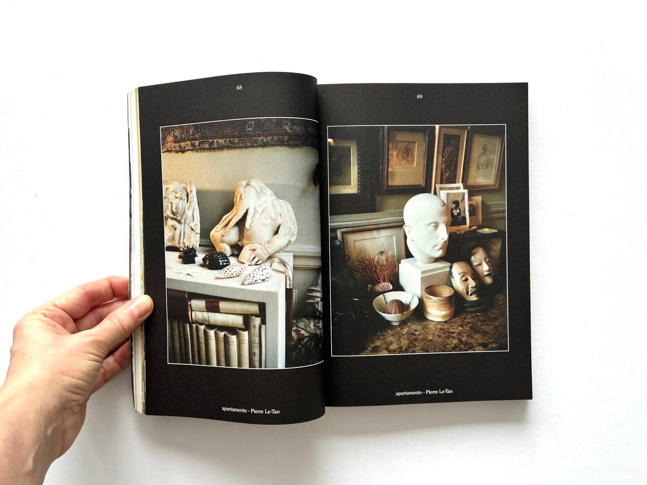 Apartamento Magazine Issue #21 – Interior spread featuring curated objects including sculptures, books, framed artworks, and decorative masks in a dimly lit interior.