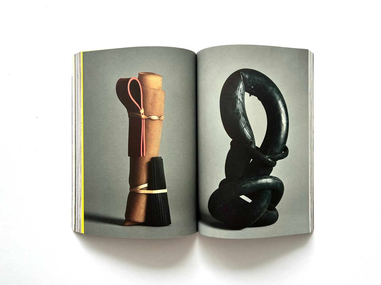Apartamento Magazine Issue #21 – Interior spread featuring sculptural design objects, including a wrapped cylindrical form and a twisted black rubber structure against a neutral backdrop.