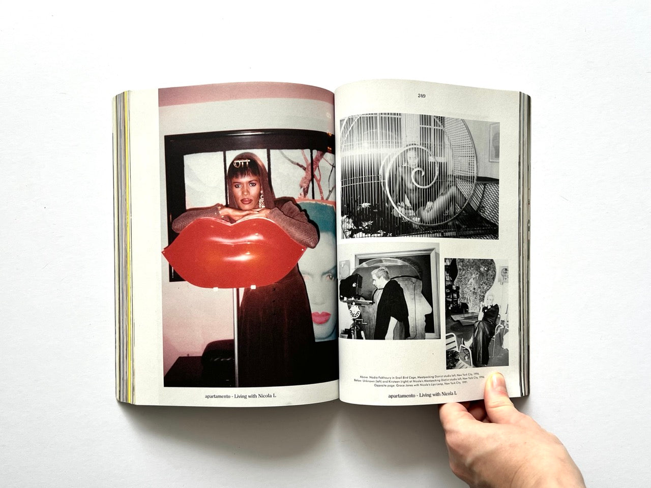 Apartamento Magazine Issue #21 – Interior spread from “Living with Nicola L” featuring a woman with a large red lips sculpture and archival black-and-white photographs.