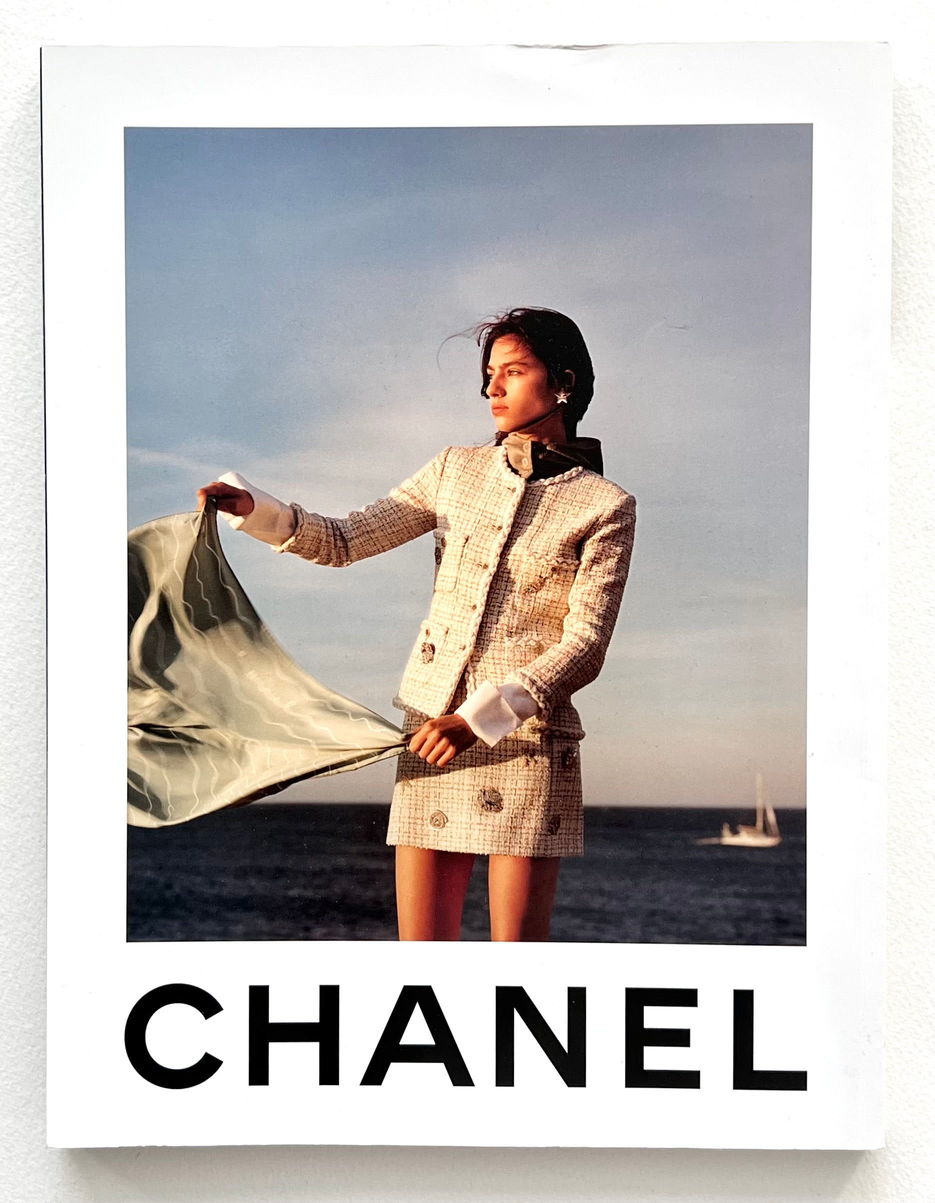 Back cover of Dazed magazine showing an advert featuring a person wearing a Chanel outfit on a beach with ocean and sky in the background