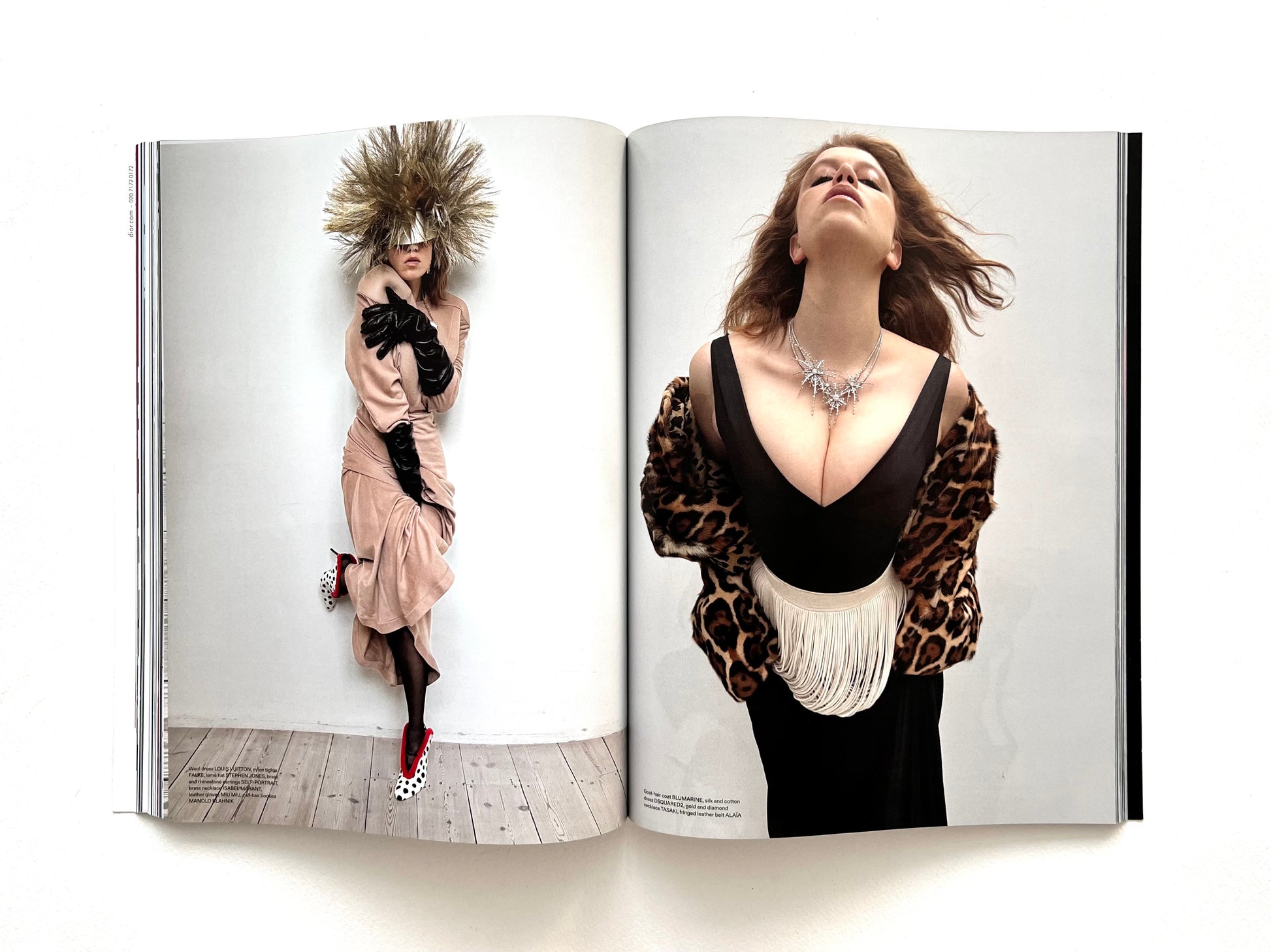 Open magazine showing two fashion models in stylish outfits on a white background