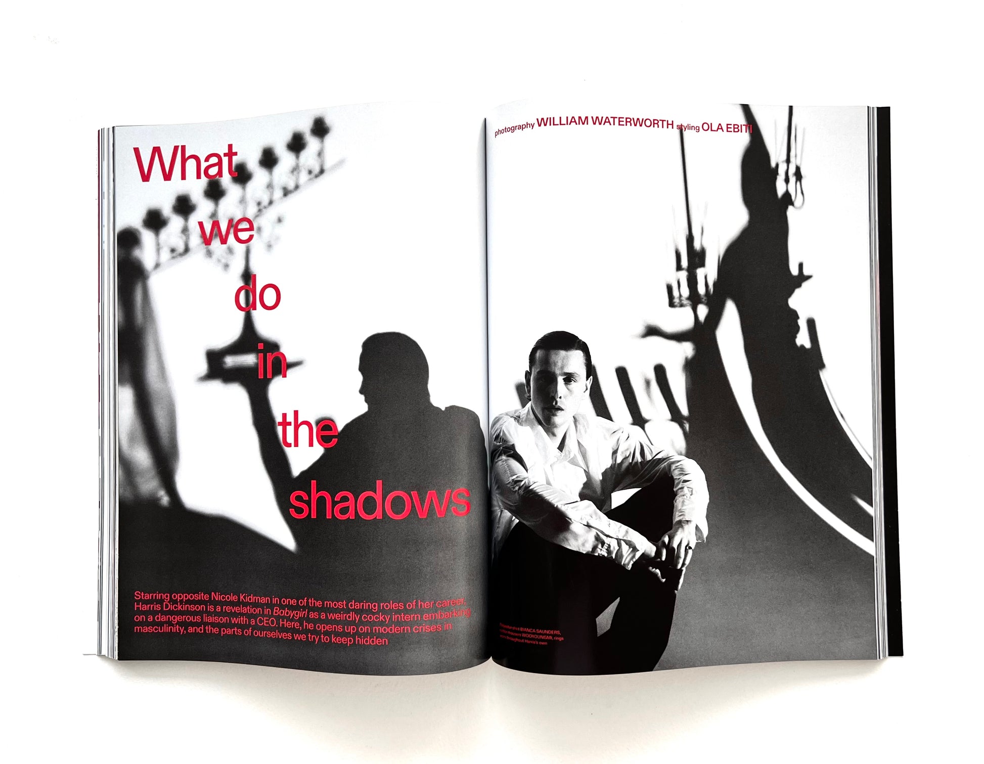 Open magazine showing black and white photo of Harris Dickinson sitting with text 'What we do in the shadows' on a white background