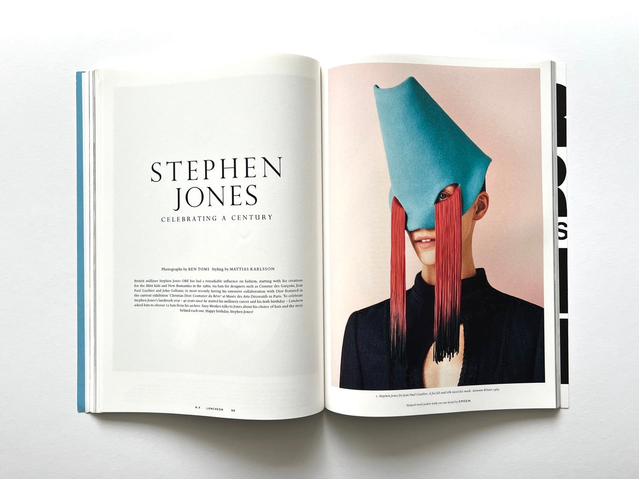 Open spread from Luncheon Magazine No. 4 with the title “Stephen Jones: Celebrating a Century” on the left, and a colour portrait on the right of a model wearing a sculptural turquoise hat with long red fringe covering the eyes.