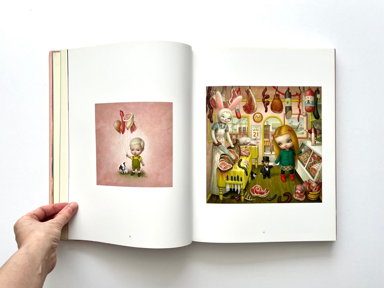 Mark Ryden Pinxit interior spread showing a small painting of a child holding meat-shaped balloons opposite a detailed butcher shop scene with surreal figures
