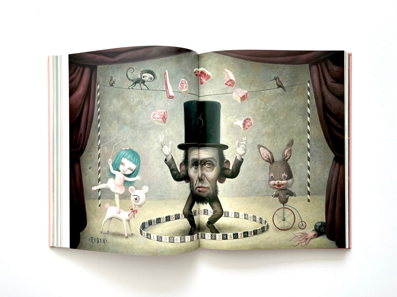 Mark Ryden Pinxit interior spread depicting a surreal stage scene with a distorted Abraham Lincoln figure juggling pieces of meat, surrounded by circus-like characters and animals