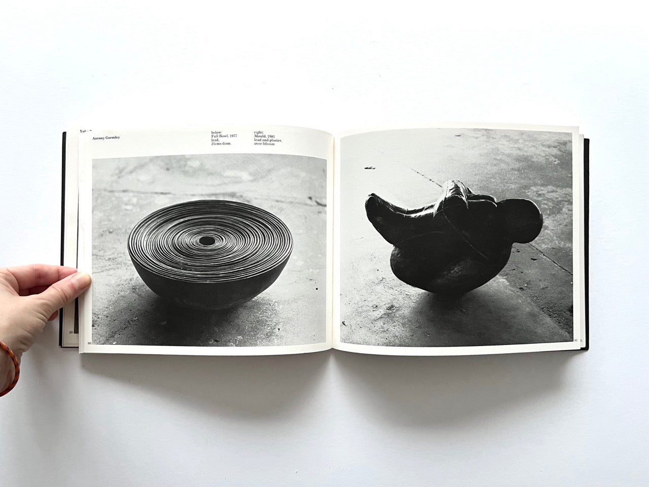 Open spread from “The Sculpture Show” (1983) with two black-and-white photographs: a coiled metal bowl-like sculpture on the left, and an abstract, compact sculptural form on the right - both by Antony Gormley.