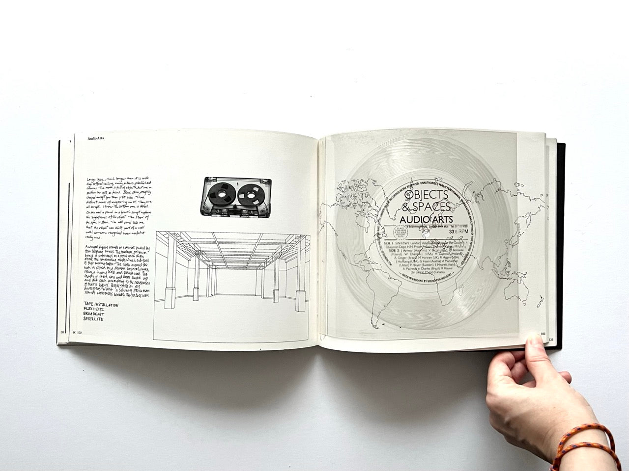 Open spread from “The Sculpture Show” (1983) featuring hand-drawn diagrams and text describing an Audio Arts installation on the left, and a translucent vinyl record with printed “Objects & Spaces / Audio Arts” label on the right