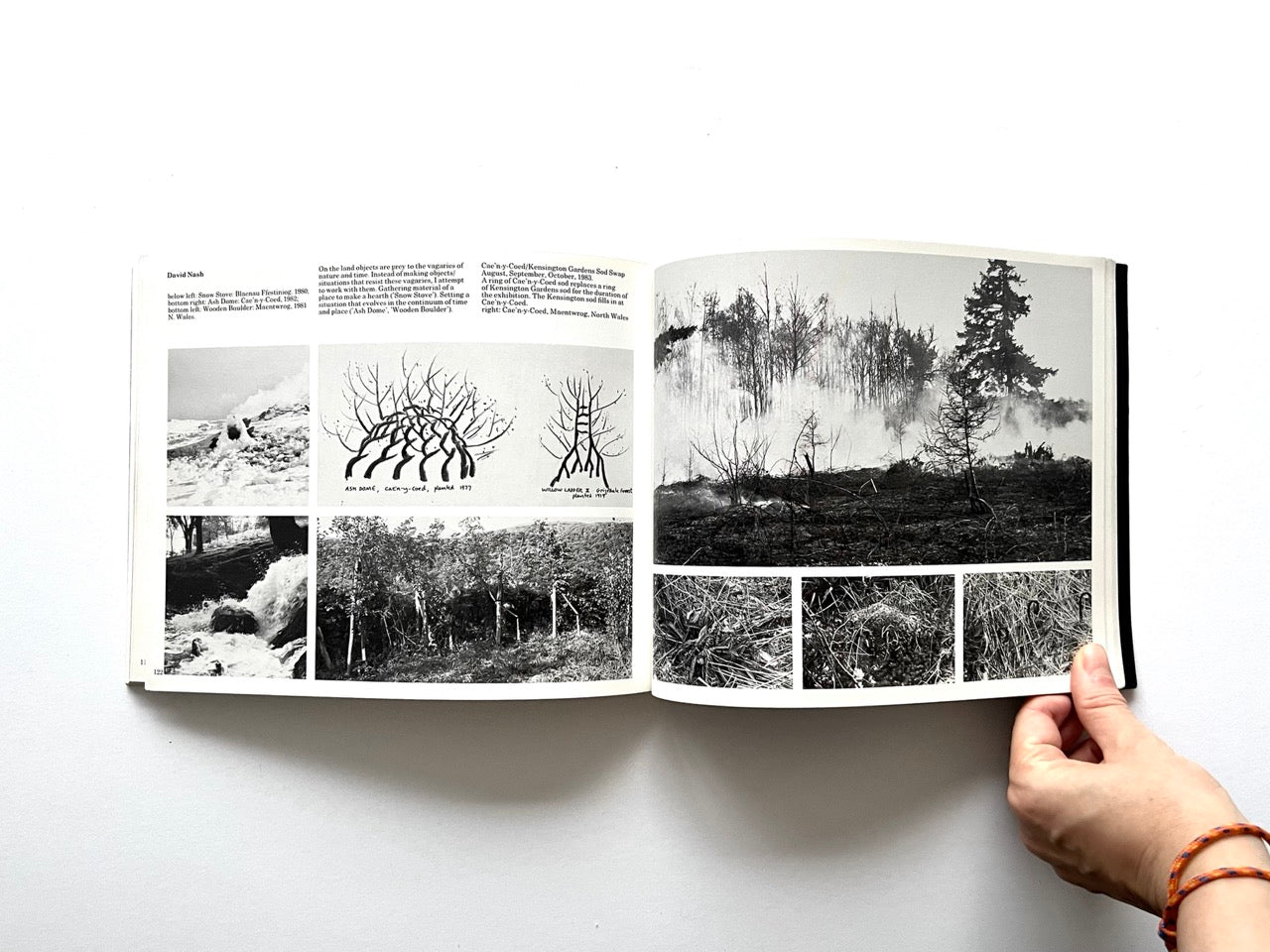 Open spread from “The Sculpture Show” (1983) featuring multiple black-and-white photographs and drawings documenting David Nash’s land art works, including burning wood sculptures, cultivated tree forms, and natural landscapes.