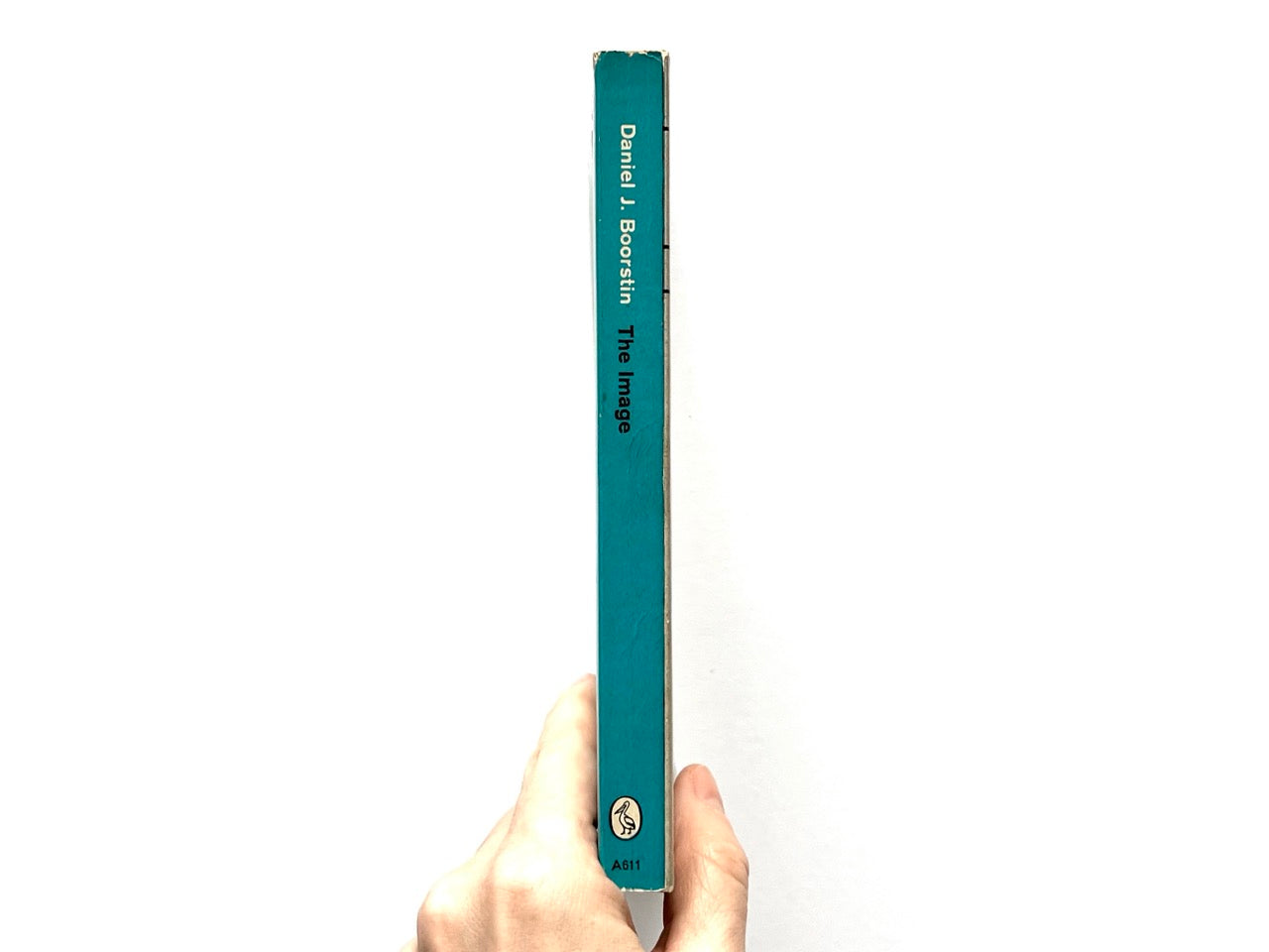Spine of the Pelican paperback edition of The Image by Daniel J. Boorstin, showing a turquoise spine with white lettering, Pelican logo at the base, and light edge wear.