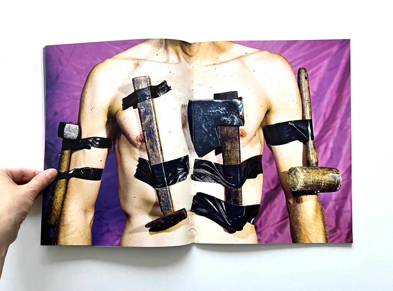 Magazine spread (Toiletpaper No. 7, December 2012) showing a male torso with several hammers and axes taped to it.